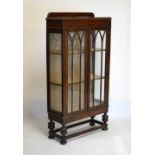 Early 20th Century oak display cabinet, fitted two shelves enclosed by a pair of glazed doors,