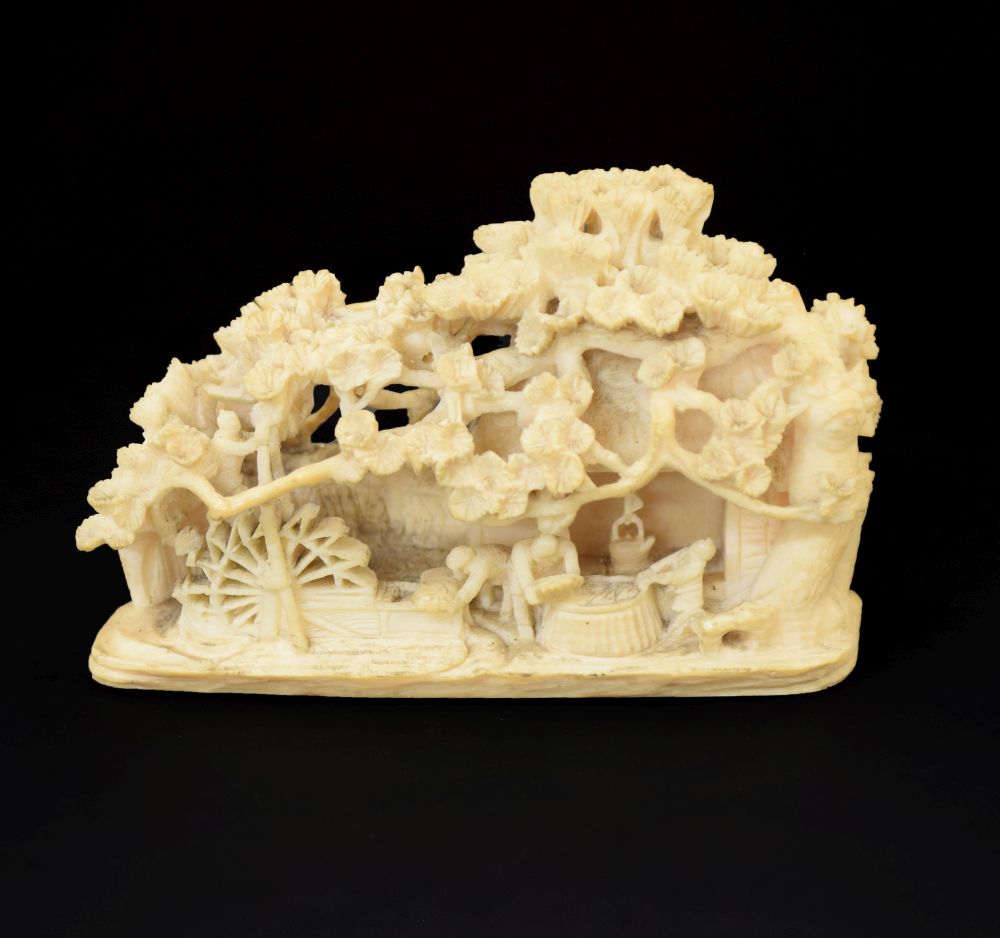 Japanese Meiji period carved ivory okimono, depicting figures outside a thatched mill cottage