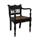 19th Century Ceylon Colonial carved ebonised hardwood elbow chair, the profusely-carved back with