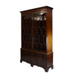 Early 20th Century mahogany library bookcase, with acanthus-carved dentil cornice over a pair of