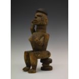 Ethnographica - African carved softwood fertility figure, modelled in seated pose with raised