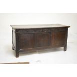 17th Century oak coffer with two plank top over three panel front and lunette frieze, 141cm wide