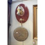 Oval velvet covered mount with horse head mask with dinner gong suspended from a lower mount,