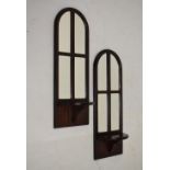 Pair of mahogany-finished console mirrors, each of arched design with shelf, each 66cm high