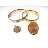 Two metal core snap bangles with yellow metal sleeves, shell cameo brooch and locket (4)