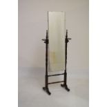 Early to mid 20th Century oak cheval mirror with frameless plate between turned uprights with candle