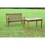 Red-stained weathered teak garden bench, 137cm wide, together with a similar table, 120cm x 70cm x
