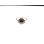 18ct gold cluster ring, the central red stone within a border of twelve small diamonds, size O½, 4.