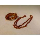 Amber bracelet of ten panel design with ball spacers, together with an amber bead necklace, 61cm