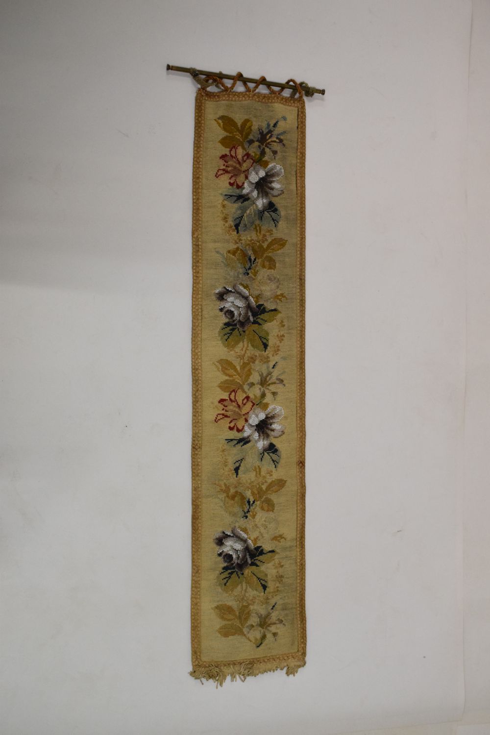 Needlework tapestry hanging, 24cm wide x 123cm high excluding brass hanging rail