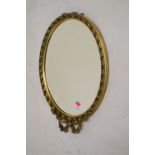 Gilt oval dressing table mirror with ribbon surmount and easel back, 55.5cm high