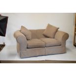 Two modern Chesterfield-style settees or sofas, each with pale brown Hessian-style loose cover and