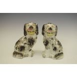 Pair of late 19th/early 20th Century Staffordshire pottery spaniels, each holding a basket of