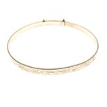 9ct gold bangle of adjustable design with wavy external decoration, 7.3g approx