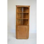 Ercol elm corner cabinet, the upper fitted two open shelves