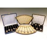 Two cased sets of six silver demi-tasse coffee spoons, one set with bean terminals, together with