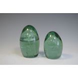 Two green glass dump paperweights, both having flower pot decoration (one at fault), tallest 13cm
