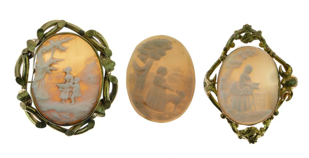 Two gilt metal shell cameo brooches, each depicting figures in landscapes, the larger 48mm x 35mm