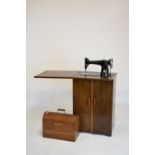 Singer sewing machine Y5710959 in original oak arch-top case, together with a sewing cabinet