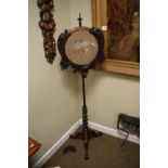 19th Century rosewood pole screen, the circular framed needlepoint screen within a rococo frame
