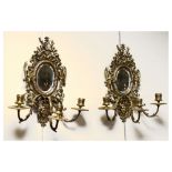 Pair of brass three branch girandole having relief decoration of cherubs, 36cm high