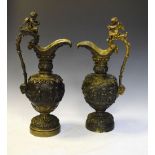 Pair of bronze decorative ewers having decoration of cherubs dancing amongst vines, 53cm high