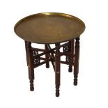 Benares-type circular brass tray on carved folding stand, 59cm diameter