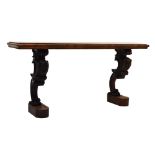 19th Century figured walnut side table raised on two heavily carved scrolling monopodia, 138cm