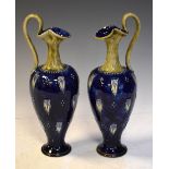 Pair of Doulton Lambeth ewers having floral decoration, 30cm high