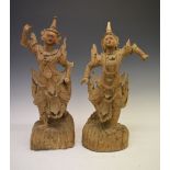 Pair of finely carved South East Asian deities on naturalistic bases, 53cm high