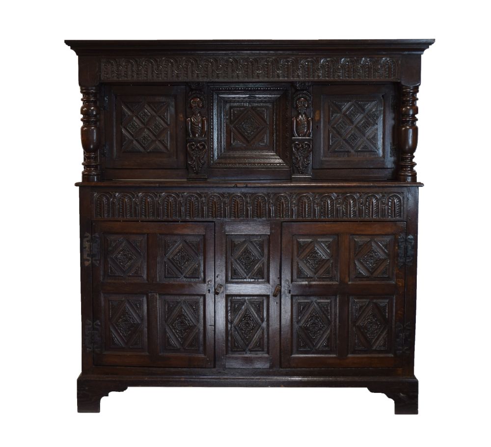 Antique oak heavily carved court cupboard fitted two geometric carved panel doors, the base with a