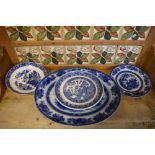 Blue and white oval meat plate, a circular Willow pattern cheese stand, and two other plates