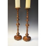 Pair of turned beech candlesticks, standing 59cm high