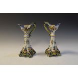 Pair of faience candlesticks, having floral decoration, a/f, 25cm high