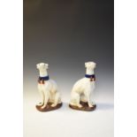 Pair of glazed pottery figures of seated greyhounds, 35.5cm high
