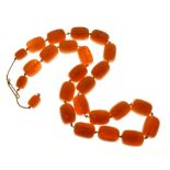 String of Bakelite amber beads as necklace, comprising 22 beads each approximately 27mm long, and