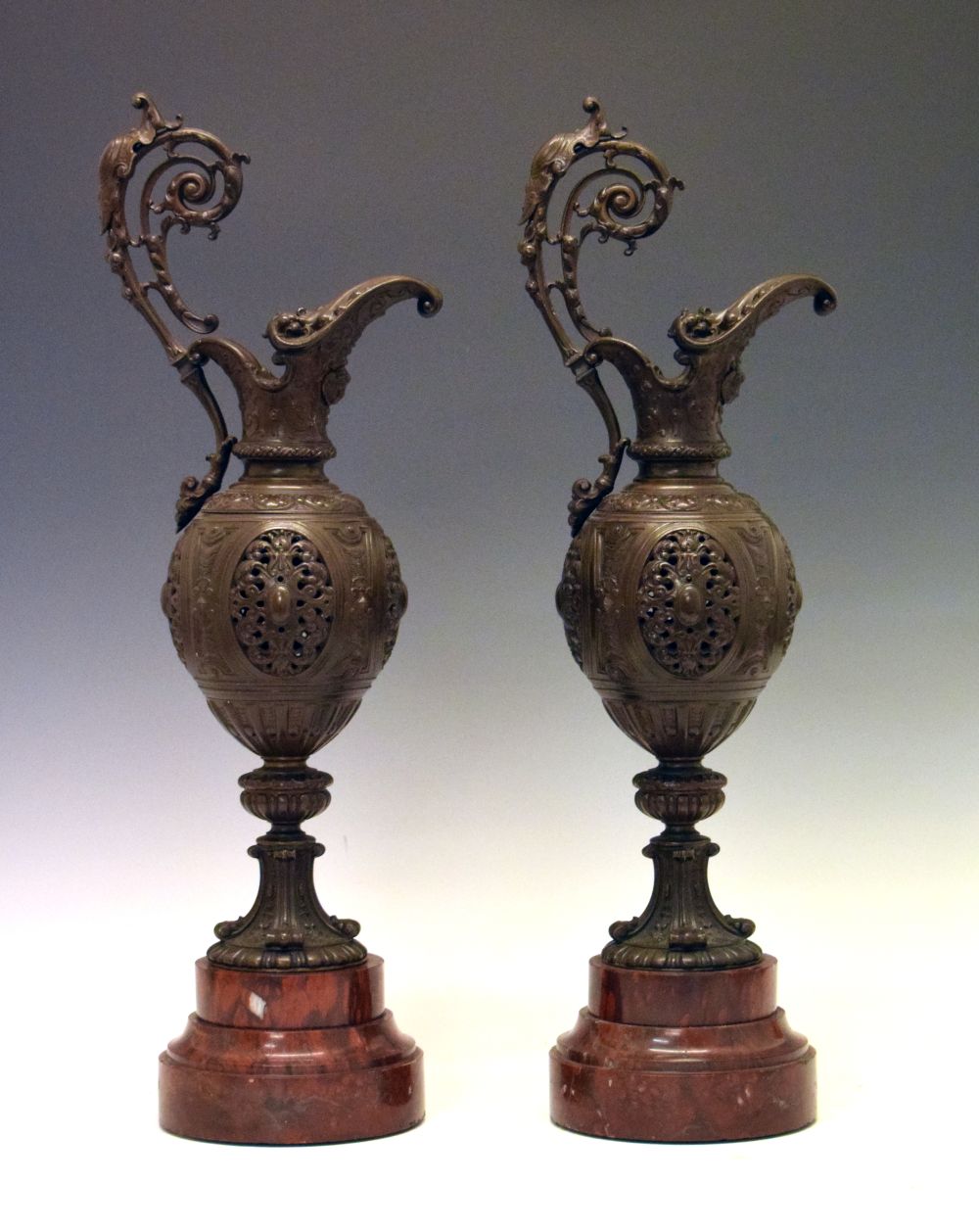 Pair of Renaissance Art revival patinated bronze ewers, each of pierced ovoid form with scroll