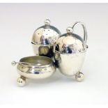 Edward VII silver condiment set, of egg shape design with scroll handle and standing on three ball