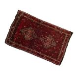 Middle Eastern wool rug, the brick-red field with two linked stepped lozenges within birds,