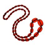 Graduated row of amber beads, 62g gross Condition: Fifty-three (53) red coloured beads, the screw