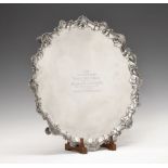 Large Edward VII silver salver, of piecrust form with scroll and shell border, standing upon four