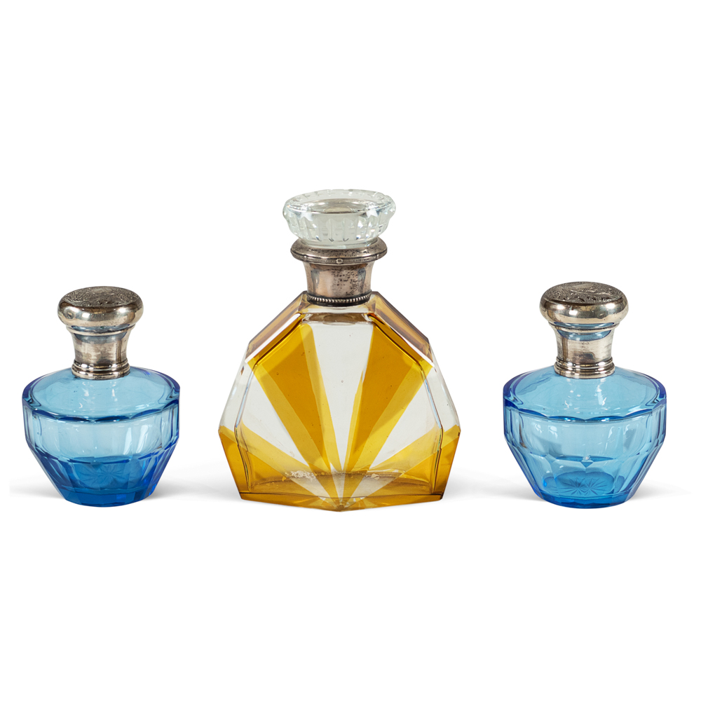 Group of perfume bottles (3) Italy, 20th century h.15 e 10,5 cm. colored glass bodies, silver and