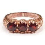 A Rose gold 9ct garnet three stone ring, size M