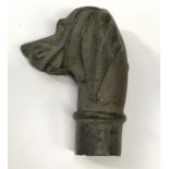 A bronze walking cane handle in the form of a dog.