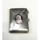 A silver case with enamel dog image.