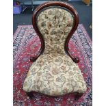 A Victorian mahogany framed spoon back ladies living chair. Buttoned back with floral upholstery.