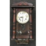 An oak cased wall clock with key.