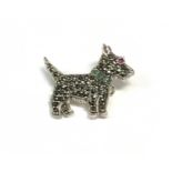 A silver dog brooch set with an emerald collar and ruby eyes.