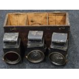 A set of three railway signal lamps in wooden box.