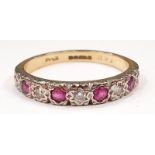 An 18ct gold ruby half eternity ring with diamond in star illusion pattern, Size P 1/2.